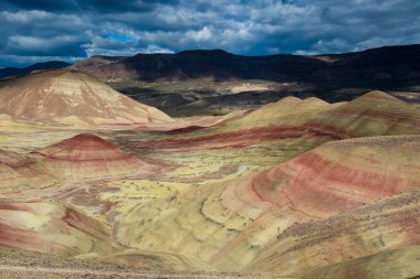 Bulutlar ve gölgeler boyalı tepelerin üzerinde