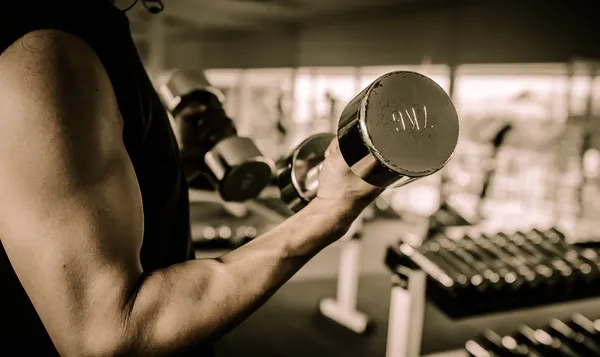 Fitness - powerful muscular man lifting weights — Stock Photo, Image