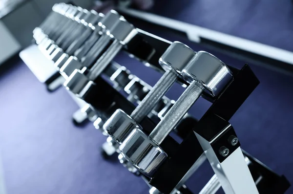 Pesos, muitos halteres de prata na sala de fitness — Fotografia de Stock