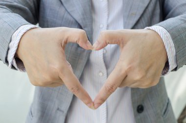 iş kadını için bir kalp şekil verme eller yukarıya kapatmak