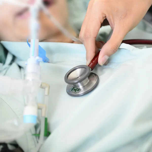 Doctor sitting in bed, examines recovering senior patient — Stock Photo, Image