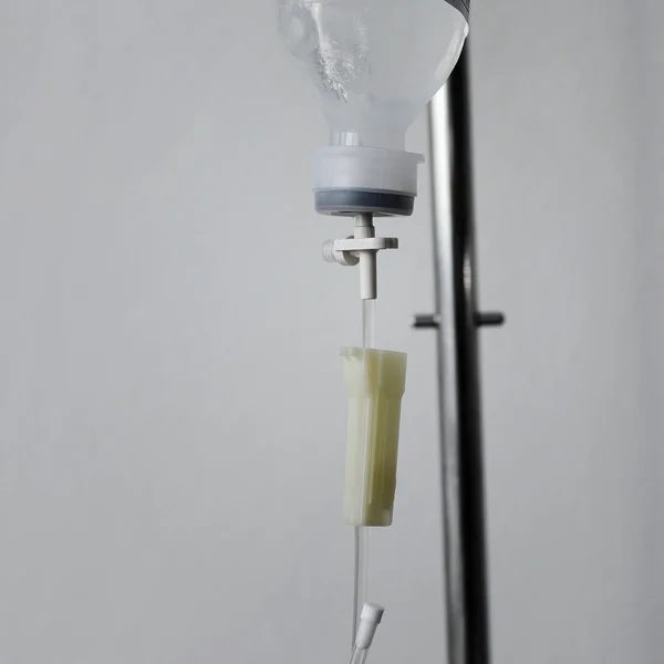 Partial view of a transparent drip bag and tubing against a whit — Stock Photo, Image