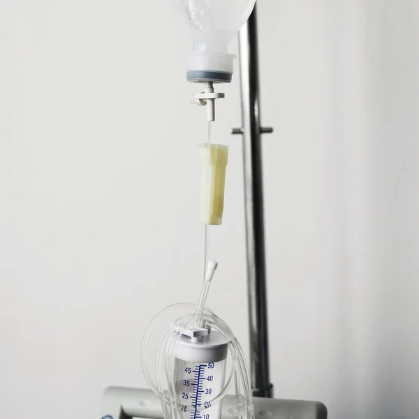 Partial view of a transparent drip bag and tubing against a whit — Stock Photo, Image