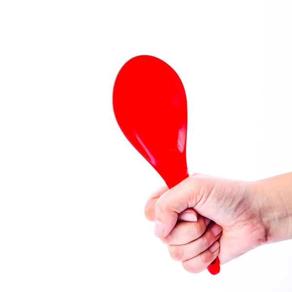 Mano sosteniendo cucharón rojo aislado sobre fondo blanco — Foto de Stock