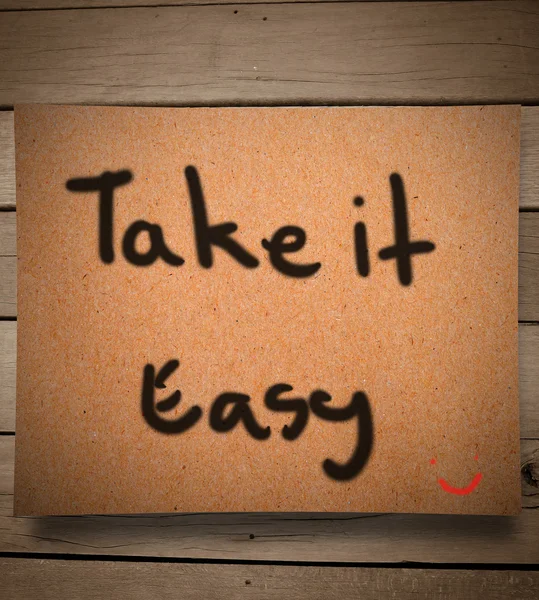 Take it easy on paper and wooden wall — Stock Photo, Image