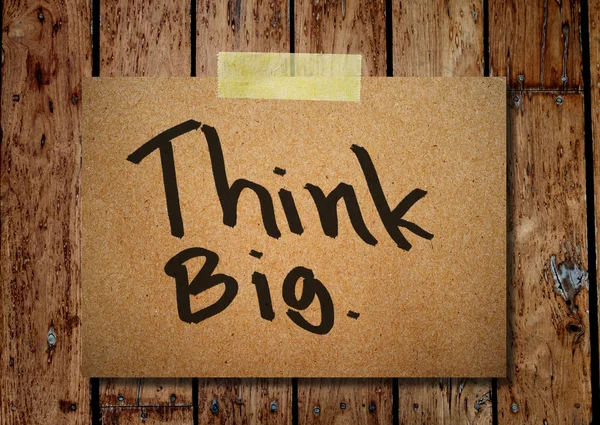 Nota carta e vestiti peg su uno sfondo di legno con Think big — Foto Stock