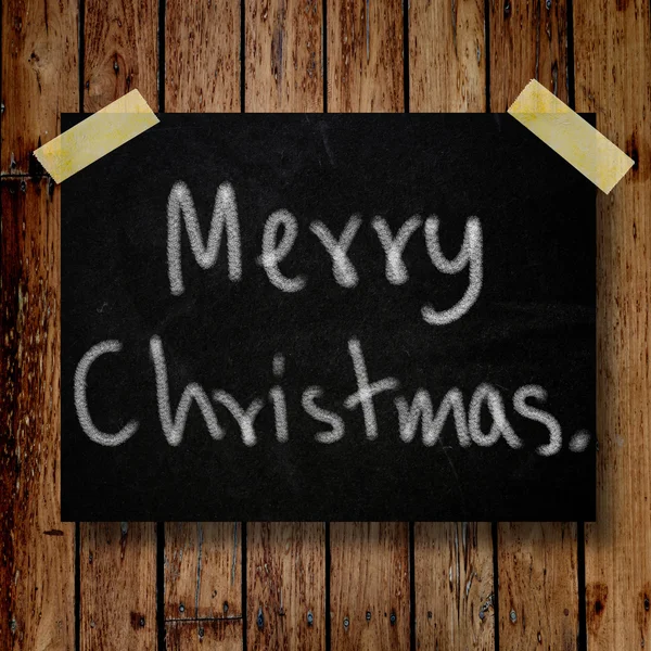 Vrolijk kerstfeest op bericht nota met houten achtergrond — Stockfoto