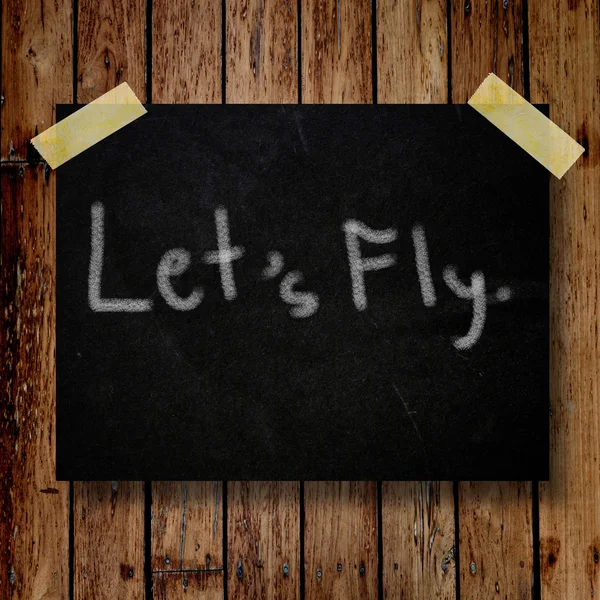 Lasst uns auf Botschaftsnotiz mit Holzhintergrund fliegen — Stockfoto