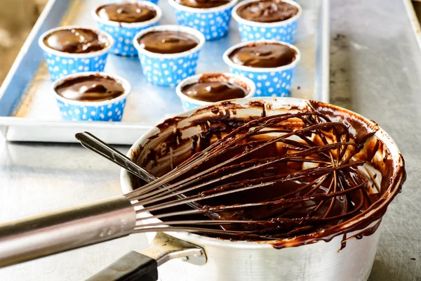 Fleißige Küche macht Schokoladenkuchen mit verschiedenen Zutaten — Stockfoto