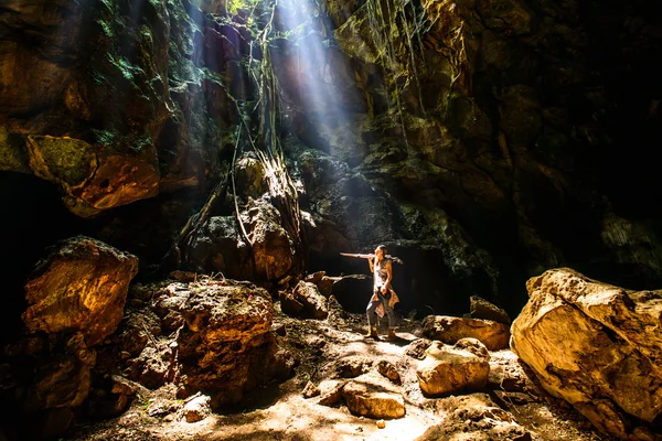 Donna in piedi nella grotta godendo la sua libertà e il cielo ligh — Foto Stock