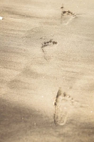 Passi sulla spiaggia di sabbia con luce calda — Foto Stock