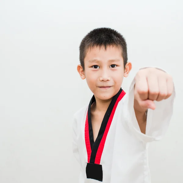 Jonge jongen opleiding taekwondo actie geïsoleerd — Stockfoto
