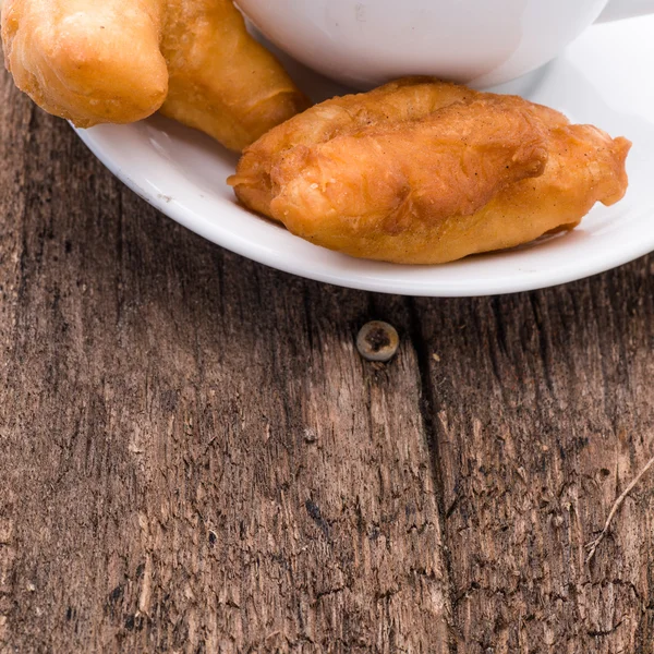 Deep fried dough stick and coffee on wooden background — Stock Photo, Image