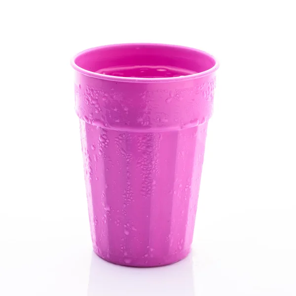Růžový plastový hrnek s kapkou vody na bílém pozadí — Stock fotografie