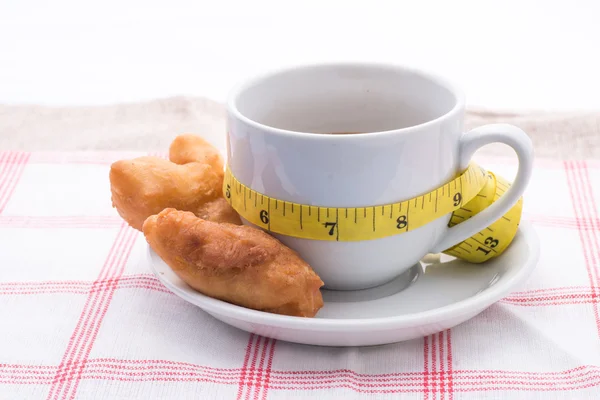 Bâton de pâte frite, café et ruban à mesurer — Photo