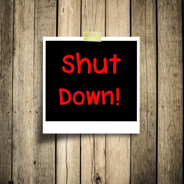 Text shut down on the black photo with wooden background — Stock Photo, Image
