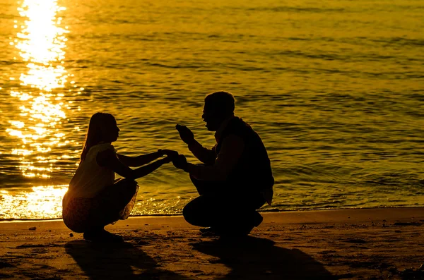 Cuplu pe plajă cu răsărit de soare — Fotografie, imagine de stoc