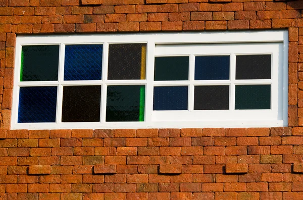 güneşli bir günde kahverengi ahşap pencere üzerinde tuğla duvar