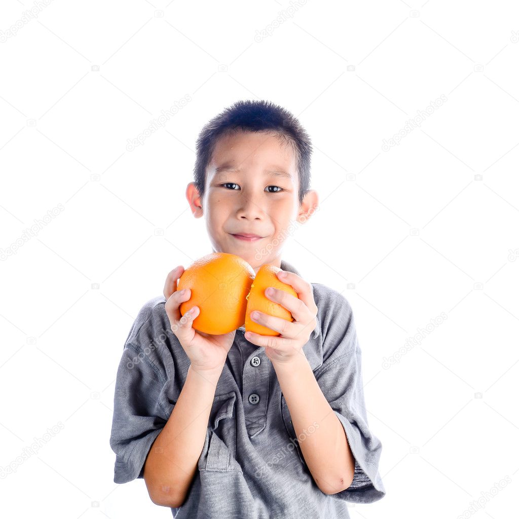 Happy Asian boy holding oranges in his hands