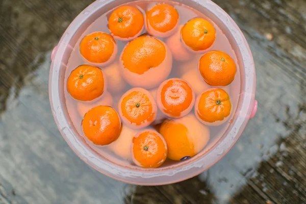 Sinaasappelen in water met natte vloer — Stockfoto