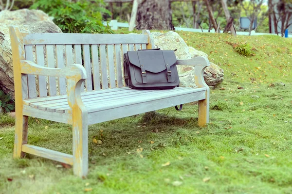Borsa in pelle vintage su una sedia nel parco, relax dal lavoro conce — Foto Stock