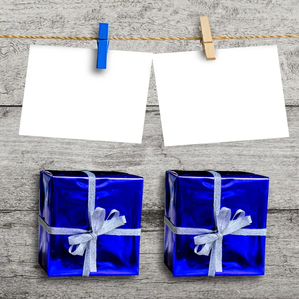 絞首刑に空白の紙と木製の壁の青いギフト ボックス — ストック写真