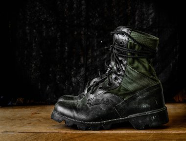 Dirty jungle boots with black background, still life clipart