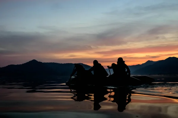 Силует солдатів, що веслують на гумовому човні на озері — стокове фото