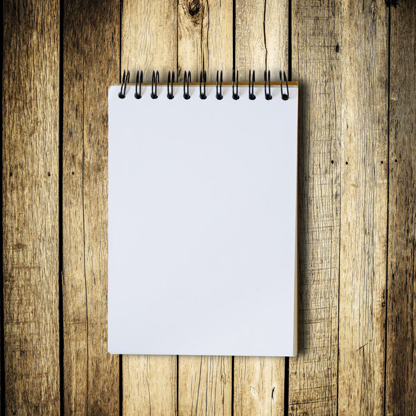 Black notebook on a wood background with clipping path