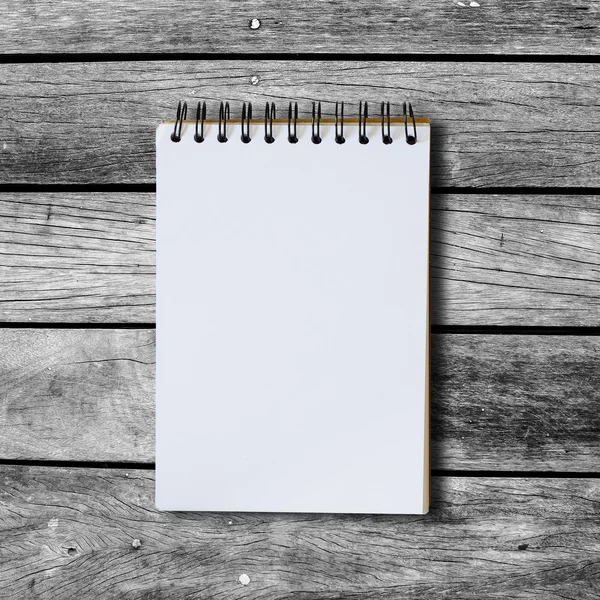 Black notebook on a wood background with clipping path — Stock Photo, Image