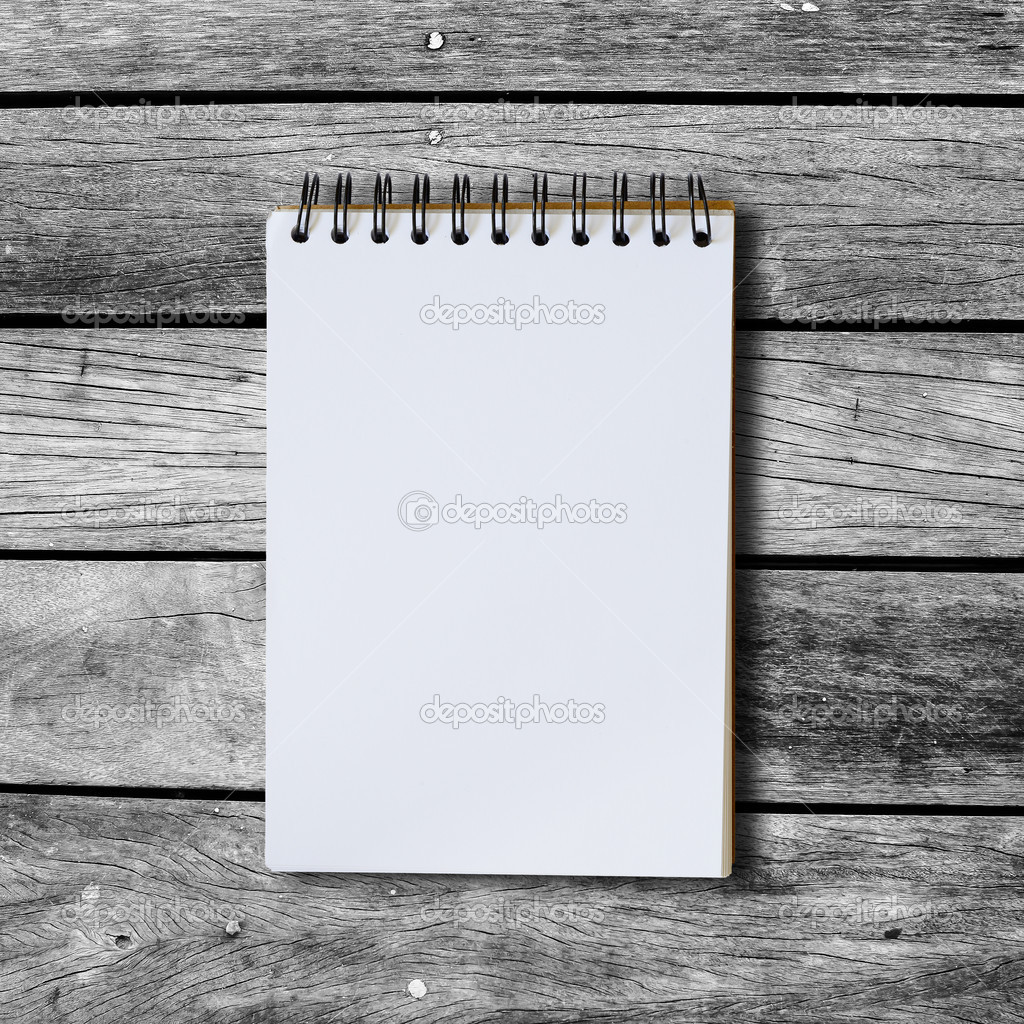 Black notebook on a wood background with clipping path