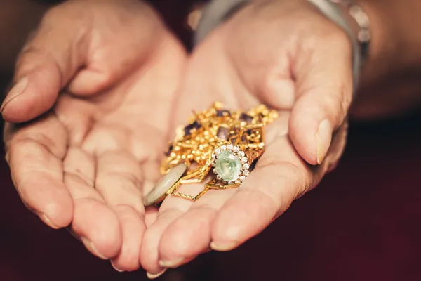 Ornamentos de ouro em uma mão com efeito de filtro vintage . — Fotografia de Stock