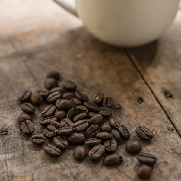 Tasse Kaffee und Kaffeebohnen auf Holz Hintergrund mit Natur l — Stockfoto