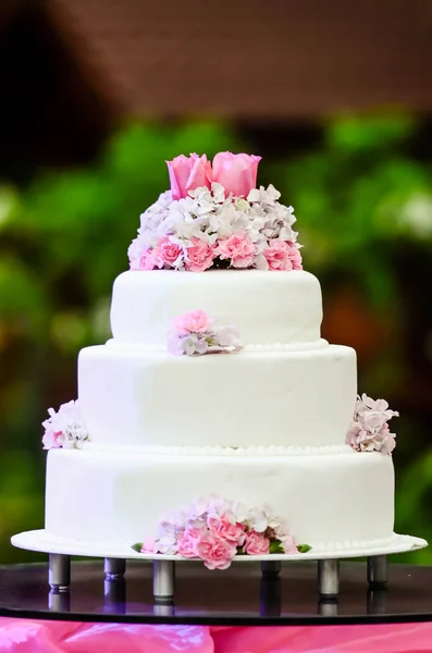 Bílá čtyři odstupňovanou svatební dort na stole — Stock fotografie