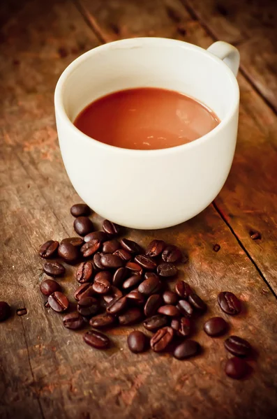 Tasse Kaffee und Kaffeebohnen auf Holz Hintergrund mit Natur l — Stockfoto