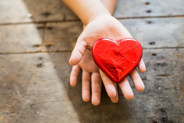 Red heart in child's hands — Stock Photo, Image