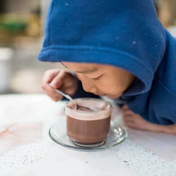 Азиатский мальчик пьет горячий шоколад по утрам . — стоковое фото