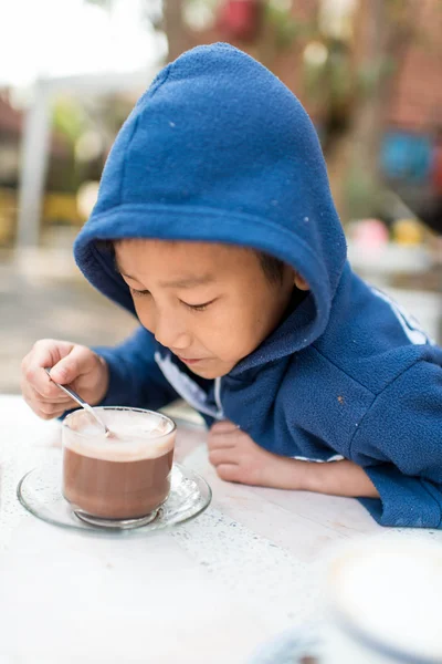 Asian boy drinking hot chocolate in the morning. — Stock Photo, Image