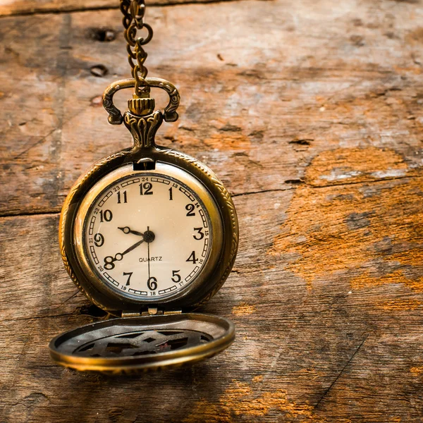 Vintage pocket watch on chain on wooden background with still li — Stock Photo, Image