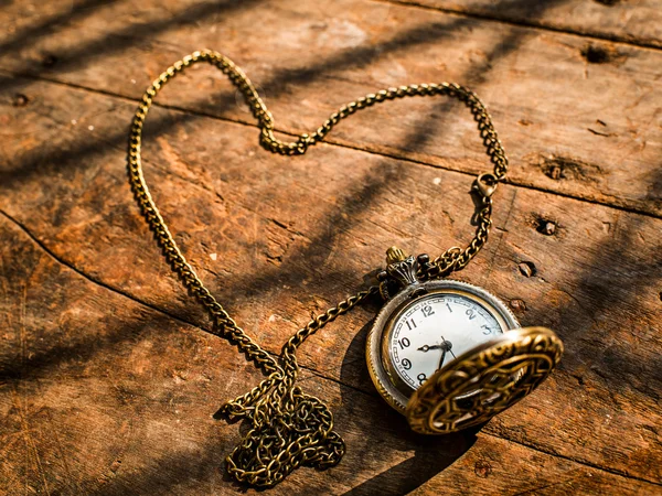 Reloj de bolsillo de corazón sobre fondo de madera con luz natural . — Foto de Stock