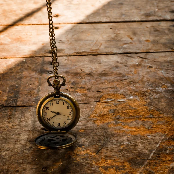 Vintage pocket watch on chain on wooden background with still li — Stock Photo, Image