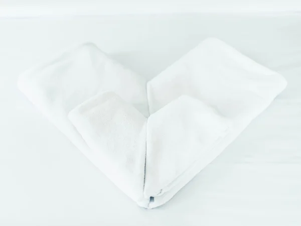 Vita rena handdukar staplade i hjärta form på Hotell sängen — Stockfoto