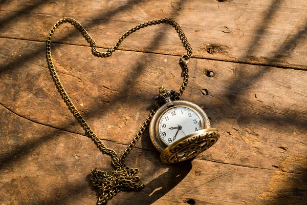 Reloj de bolsillo de corazón sobre fondo de madera con luz natural . —  Fotos de Stock