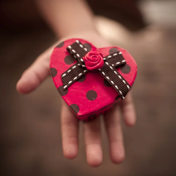 Red heart box in child 's hands — стоковое фото