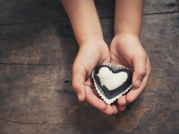 Любовная записка на черно-белом шоколаде в руке ребенка — стоковое фото
