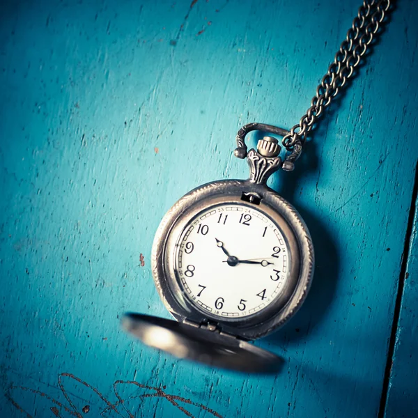Reloj de bolsillo de estilo antiguo sobre fondo de madera azul —  Fotos de Stock