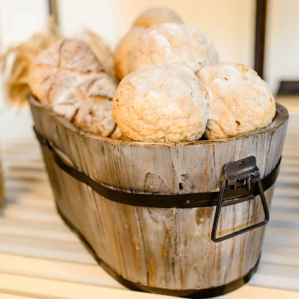 Variety of bread in basket on wooden shelf. — Stock Photo, Image