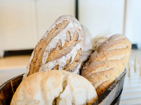 Variety of bread in basket on wooden shelf. — Stock Photo, Image