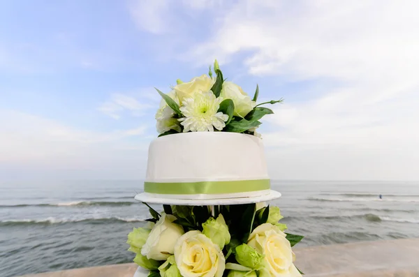 Weiß und Rosen Hochzeitstorte am Strand — Stockfoto