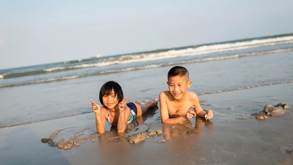 Thai brother and sister ages 8 and 5 have fun on the beach — Stock Photo, Image